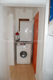 Utility area next to orange door of the shower room