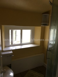 Smaller bathroom with shower, basin and toilet. 