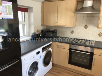 Kitchen with washing machine & tumble dryer. 