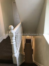 Freshly painted bannisters. Staircase leading down to front door. 