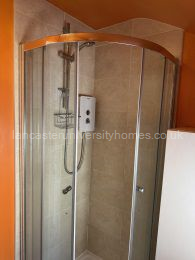 Smaller bathroom with shower, basin and toilet.