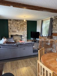 Middle-floor open-plan lounge & kitchen. L-shaped sofa and kitchen table & chairs bought in 2025. 52-inch smart tv. 